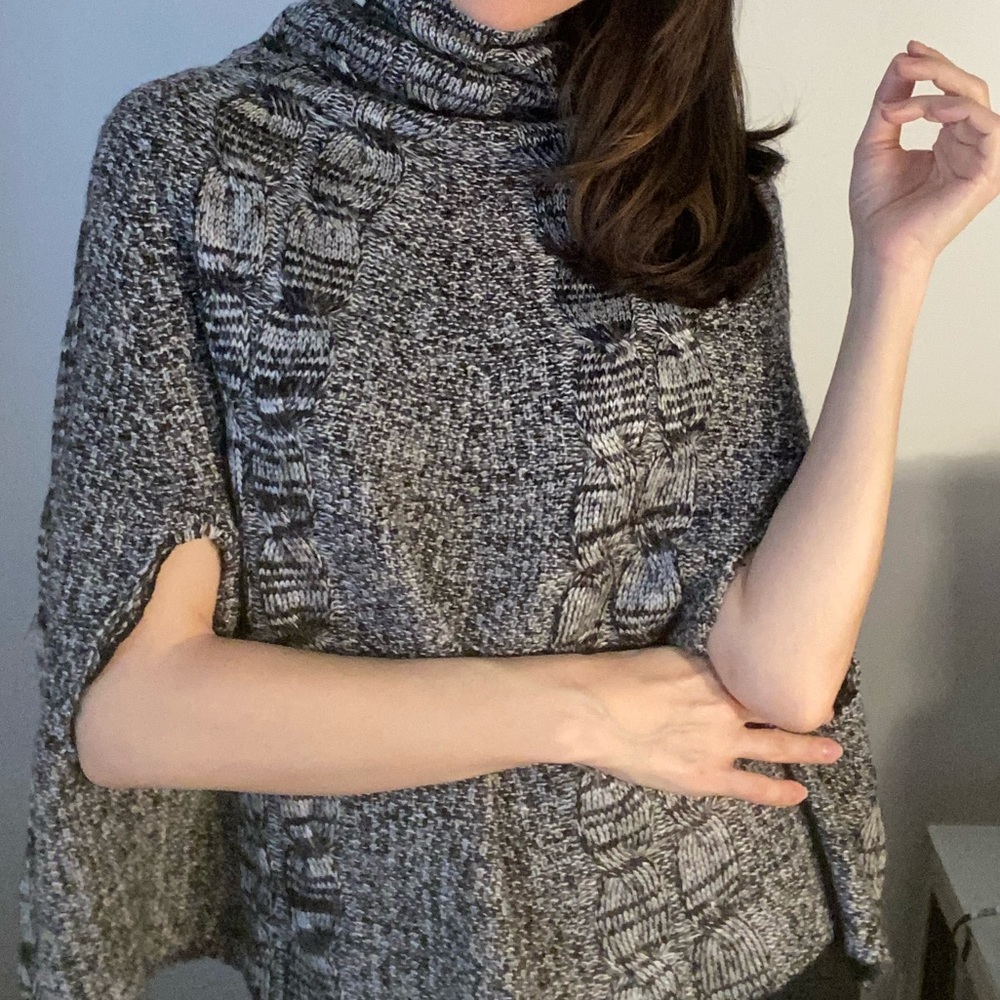 Cape style black and white turtleneck sweater.